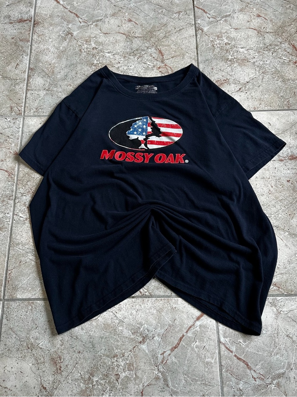 Mossy Oak Black Tee with American Flag Logo and Red Text